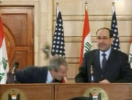 FILE PHOTO: Video frame grab of U.S. President George W. Bush (L) ducking from a shoe during a news conference in Baghdad December 14, 2008. REUTERS/Reuters TV/File Photo