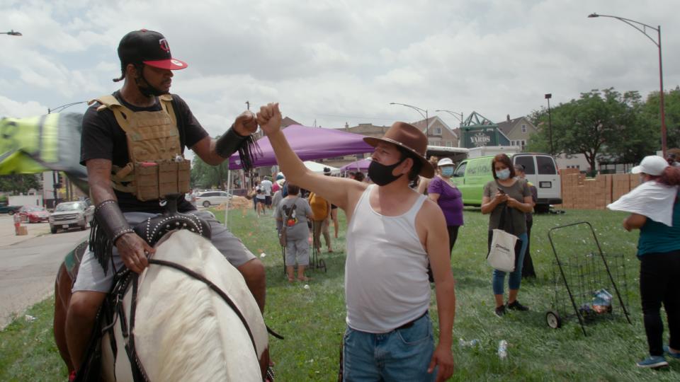 The Census Cowboy fist bumps a man in a cowboy hat.<span class="copyright">PM Chicago Story, LLC</span>