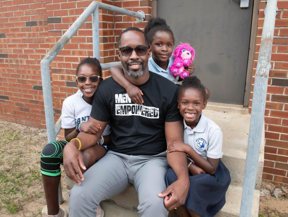 Casey Johnson, founder of Men Empowered, poses with his daughters, from left, Skylar, 11, Sloan, 5, and Shelby, 8, in Pensacola on Thursday, Sept. 28, 2023.