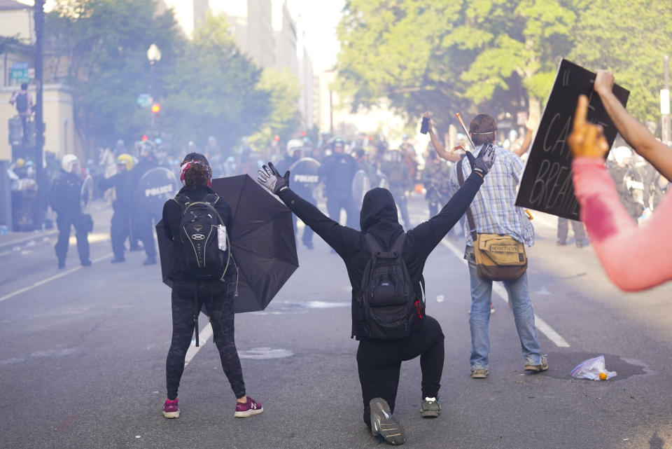 Demonstrators kneel in front of a line of police officers during a protest for the death of George Floyd, Monday, June 1, 2020, near the White House in Washington. Floyd died after being restrained by Minneapolis police officers. (AP Photo/Evan Vucci)