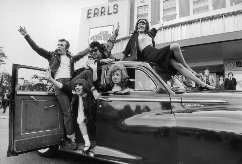 24th October 1973:  The cast of the show ‘Grease’, a new 1950’s rock and roll musical, arrive at Earls Court London for the 1973 Motor Show driving a Chrysler Windsor circa 1950 (Getty Images)