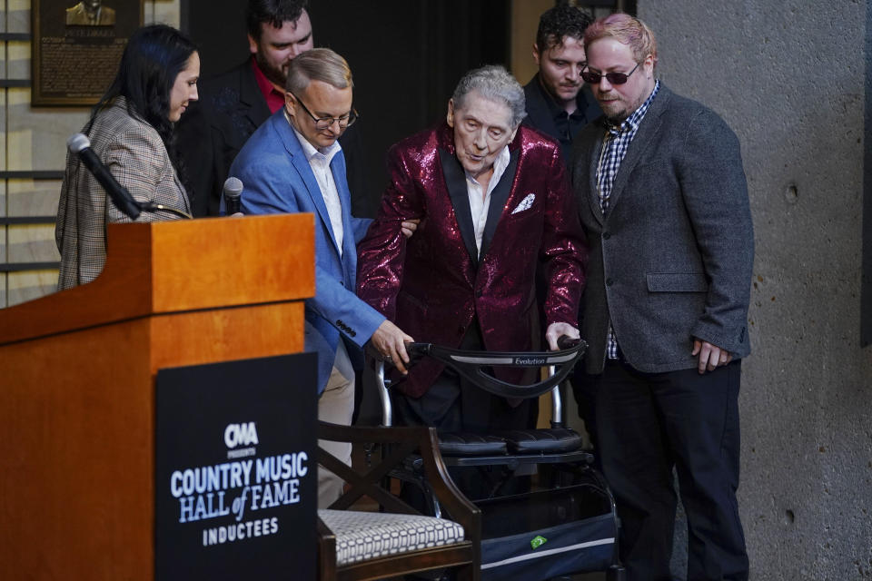 Jerry Lee Lewis is helped to a chair at the Country Music Hall of Fame after it was announced he will be inducted as a member Tuesday, May 17, 2022, in Nashville, Tenn. (AP Photo/Mark Humphrey)