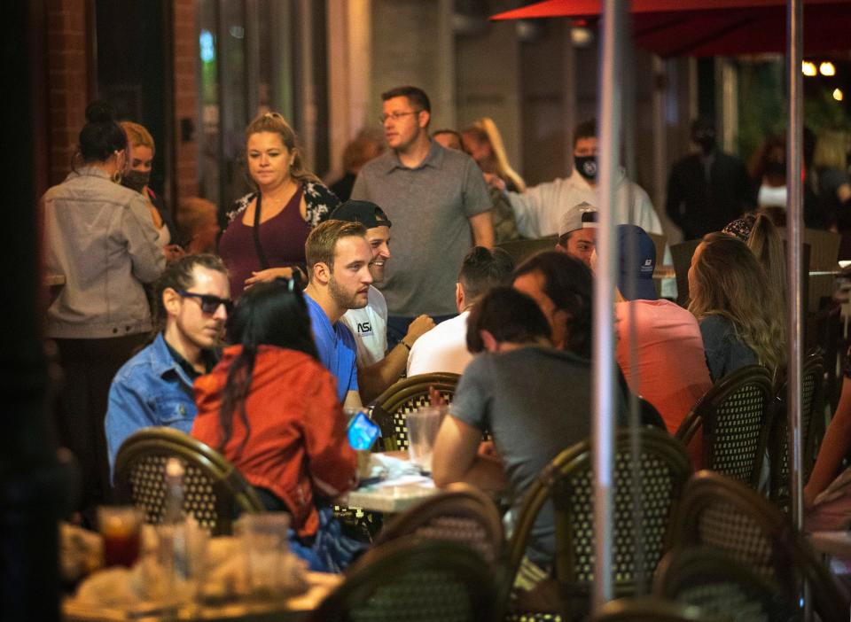 People dine at Duffy's on Clematis Street in downtown West Palm Beach Saturday night, March 20, 2021. State and local officials have been reluctant to reimpose lockdowns or restrictions that might jeopardize businesses. Instead, they are relying heavily on personal responsibility in the hopes that individuals will, collectively, make the right decisions to curb the virus's spread to follow rules for mask-wearing and social distancing.