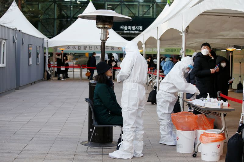 A woman undergoes the coronavirus disease (COVID-19) test at a testing site at City Hall Plaza in Seoul