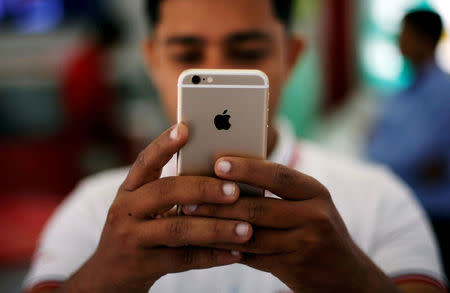 FILE PHOTO: A salesman checks a customer's iPhone at a mobile phone store in New Delhi, India, July 27, 2016. REUTERS/Adnan Abidi/File Photo