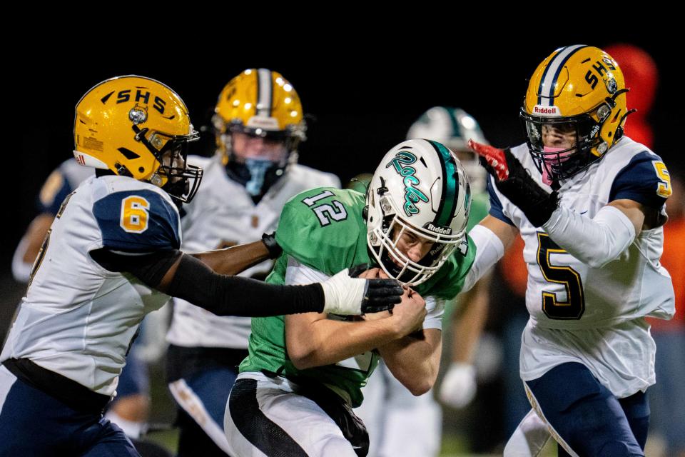 Dublin Coffman's Quinn Hart (12) tries to make his way through Springfield's Javyn Martin (6) and Aaron Scott (5) during Friday night's regional final.