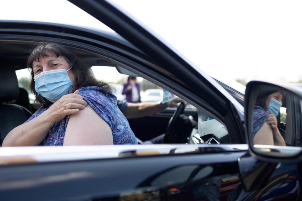 A woman waits in her car to receive a dose of a COVID vaccine at a clinic run by Skippack Pharmacy in Lansdale, Pennsylvania, April 18, 2021. REUTERS/Hannah Beier