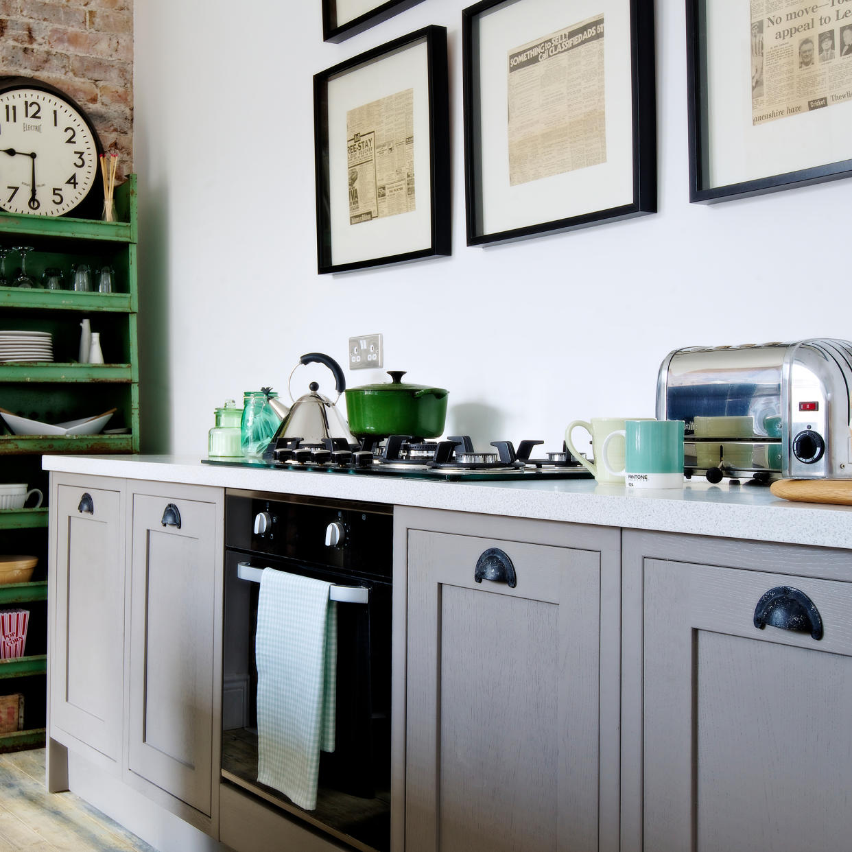  Kitchen with grey cabinetry and green open storage unit. 