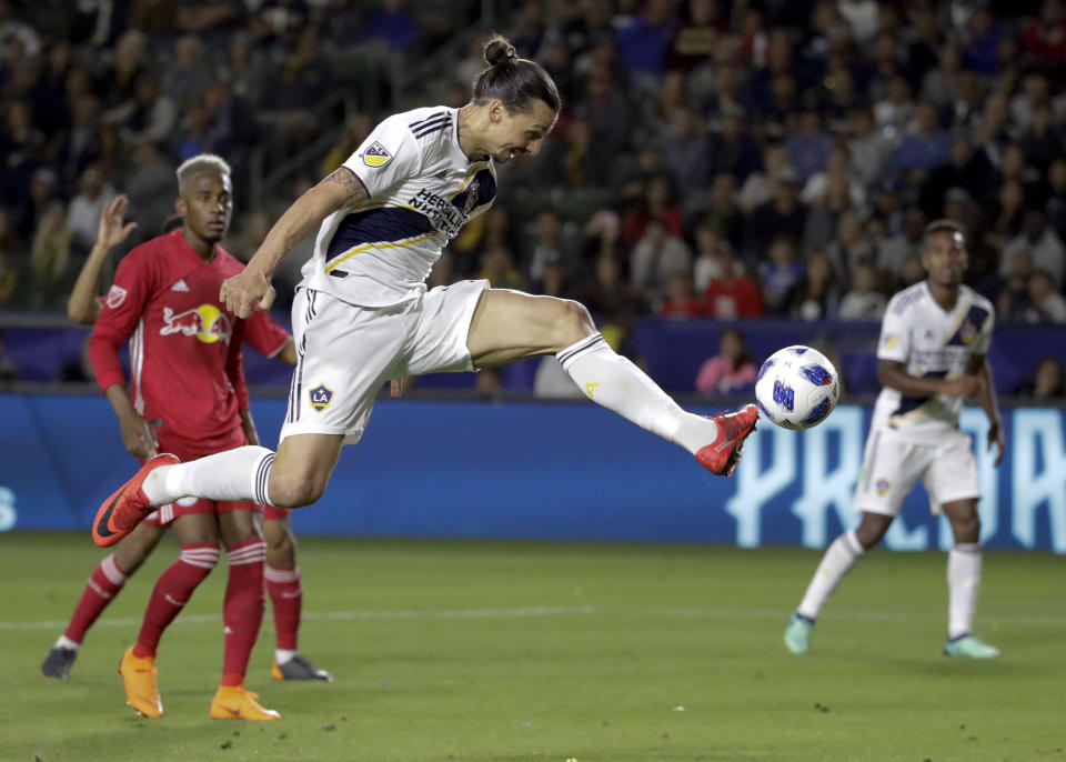 FILE - In this April 28, 2018, file photo, LA Galaxy forward Zlatan Ibrahimovic kicks the ball into the goal during the second half of an MLS soccer match against the New York Red Bulls, in Carson, Calif. The goal was later disallowed. Zlatan Ibrahimovic is returning to the Los Angeles Galaxy. A person with knowledge of the deal confirms the 37-year-old striker will play next season for the Galaxy. The person spoke on the condition of anonymity because the team had not yet formally announced it. (AP Photo/Chris Carlson, File)