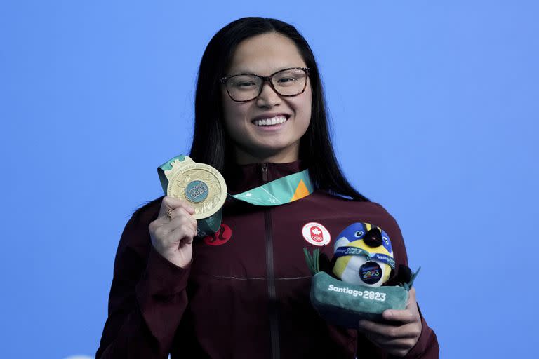 La canadiense Maggie McNeil posa con su medalla de oro tras ganar los 100 metros mariposa en la natación de los Juegos Panamericanos en Santiago, Chile