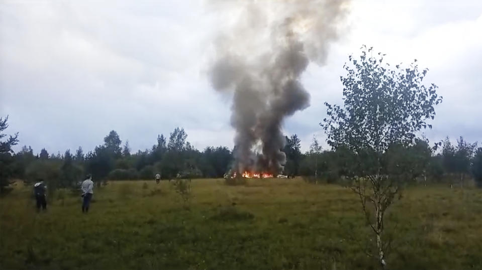 In this image taken from video, smoke and flames rise from a crashed private jet near the village of Kuzhenkino, Tver region, Russia, Wednesday, Aug. 23, 2023. Russian mercenary leader Yevgeny V. Prigozhin, the founder of the Wagner Group, reportedly died when a private jet he was said to be on crashed on Aug. 23, 2023, killing all 10 people on board. (AP Photo)