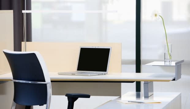 Empty desk with laptop in modern office