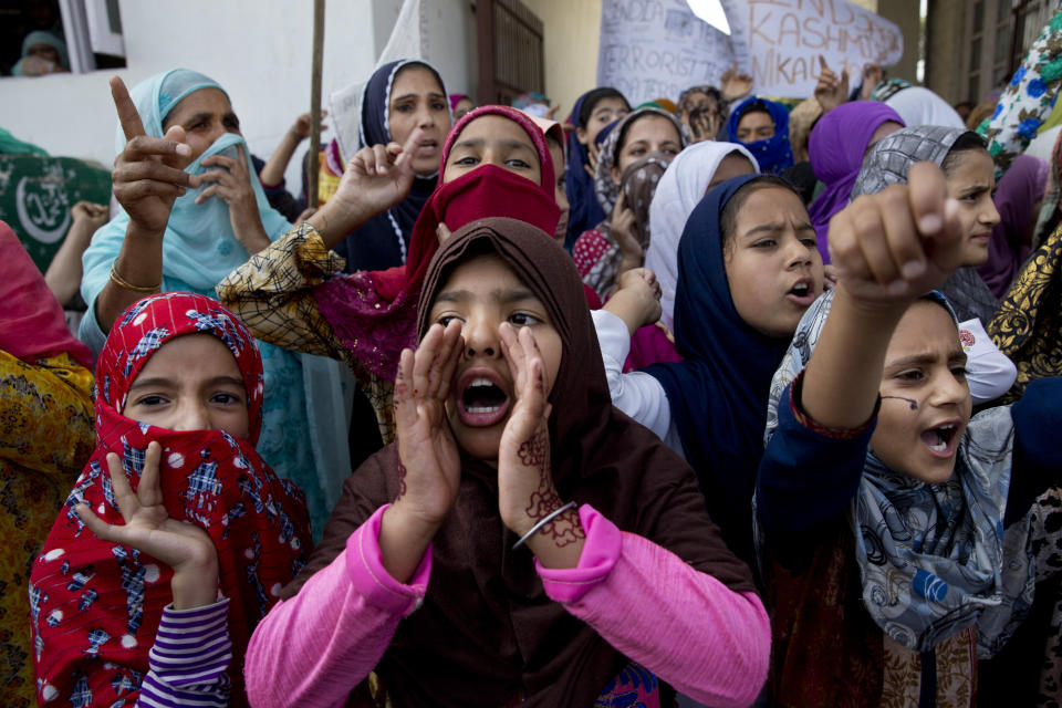 FILE- In this Sept. 27, 2019 file photo, Kashmiri girls shout freedom slogans during a protest after Indian government scrapped the region's semi-autonomy and imposed an unprecedented security clampdown in Srinagar, Indian controlled Kashmir. India’s Prime Minister Narendra Modi will attend a groundbreaking ceremony next month for a Hindu temple on a disputed site in northern India where a 16th-century mosque was torn down by Hindu hard-liners in 1992. The trust overseeing the temple construction says the ceremony is set for Aug. 5, a date they say is astrologically auspicious for Hindus but that also marks a year since the Indian Parliament revoked the semi-autonomous status of its only Muslim-majority state, Jammu and Kashmir. (AP Photo/Dar Yasin, File)