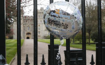 A balloon left by a member of the public hangs outside the gates of Windsor Castle, a day after the death of Britain's Prince Philip, in Windsor, England, Saturday, April 10, 2021. Britain's Prince Philip, the irascible and tough-minded husband of Queen Elizabeth II who spent more than seven decades supporting his wife in a role that mostly defined his life, died on Friday. (AP Photo/Frank Augstein)