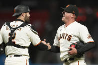 San Francisco Giants catcher Curt Casali, left, celebrates with relief pitcher Jake McGee after the Giants defeated the Miami Marlins in a baseball game in San Francisco, Thursday, April 22, 2021. (AP Photo/Jeff Chiu)