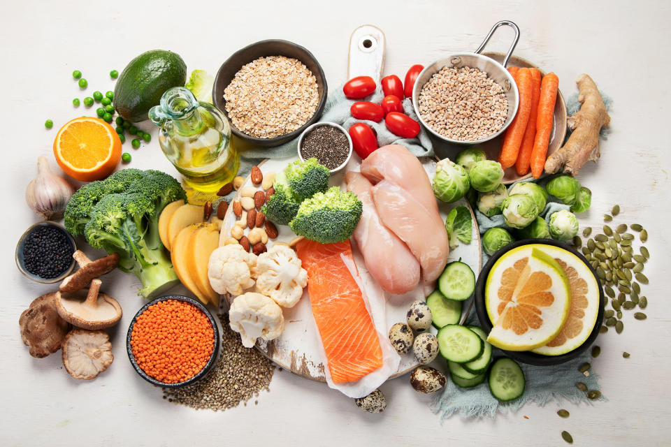 Healthy food selection on white background. Detox and clean diet concept. Foods high in vitamins, minerals and antioxidants. Anti age foods. Top view.