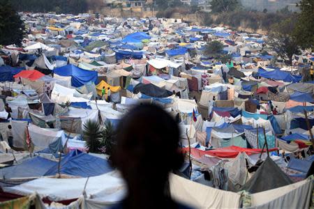 A boy stands at a makeshift camp on the grounds of the Petionville Golf Course in Port-au-Prince, Haiti in this January 26, 2010 file photo. REUTERS/Carlos Barria/Files