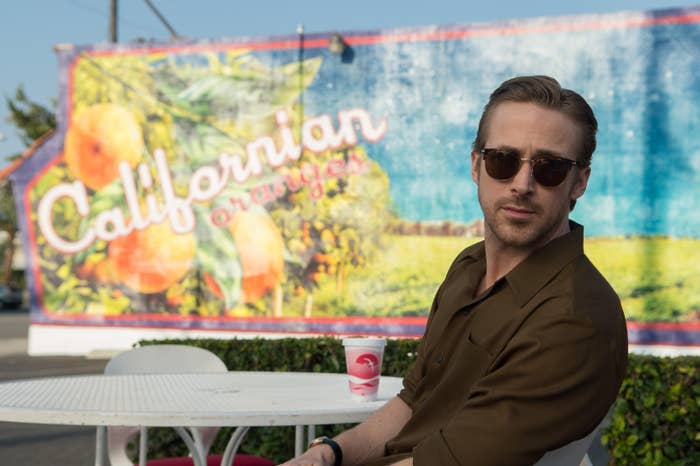 Man in sunglasses and a brown shirt sitting in front of a mural with text "Californian oranges."