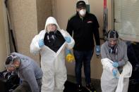 Members of a cleaning crew leave the Life Care Center of Kirkland, the Seattle-area nursing home at the epicenter of one of the biggest coronavirus outbreaks in the United States, in Kirkland