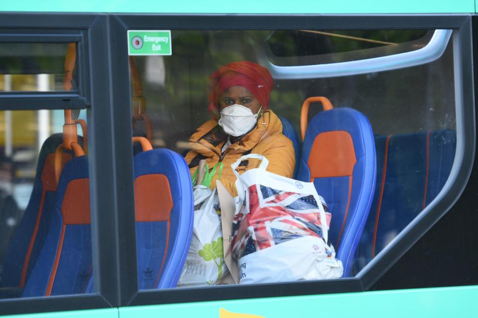 A woman wears a protective face mask on a bus in central Manchester on June 5, 2020, as lockdown measures are eased during the novel coronavirus COVID-19 pandemic. - Face coverings will soon be compulsory for people wanting to travel on public transport in England to limit the spread of coronavirus. (Photo by Oli SCARFF / AFP) (Photo by OLI SCARFF/AFP via Getty Images)