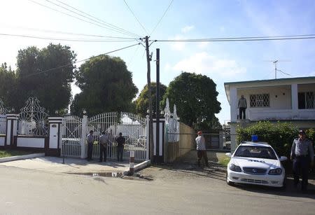 Police stand at the fence surrounding the house of Gilberto Martinez in Havana January 10, 2015. REUTERS/Stringer