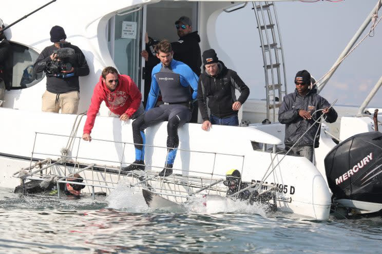 Michael Phelps and the crew watch a shark approach the cage, which Phelps is about to enter. (Photo: Discovery)