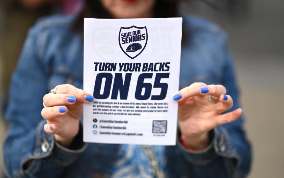 A Tottenham holding up a leaflet ahead of a protest during the match