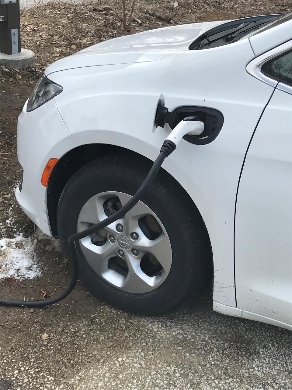 A hybrid vehicle owned by the state Department of Conservation and Natural Resources is hooked up to one of two electric vehicle charging stations at the Tom Ridge Environmental Center in Millcreek Township in this file photo.