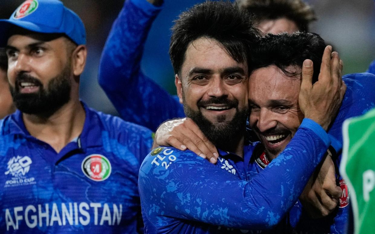 Afghanistan's captain Rashid Khan, centre, embraces teammate Gulbadin Naib as they celebrate defeating Bangladesh by eight runs in their men's T20 World Cup cricket match at Arnos Vale Ground, Kingstown, Saint Vincent and the Grenadines, Monday, June 24, 2024