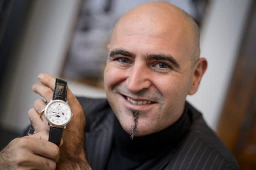 CEO of Swiss watchmakers Blancpain, Marc Hayek, poses with a Chinese-themed limited edition model of a watch which shows the Chinese time and calendar, as well as the signs of the zodiac and phase of the Moon