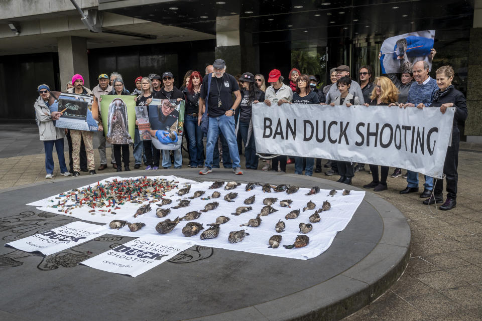 Levy leading the ban duck shooting protest. Several protesters stand behind him. Dead ducks are laid out in front of them.