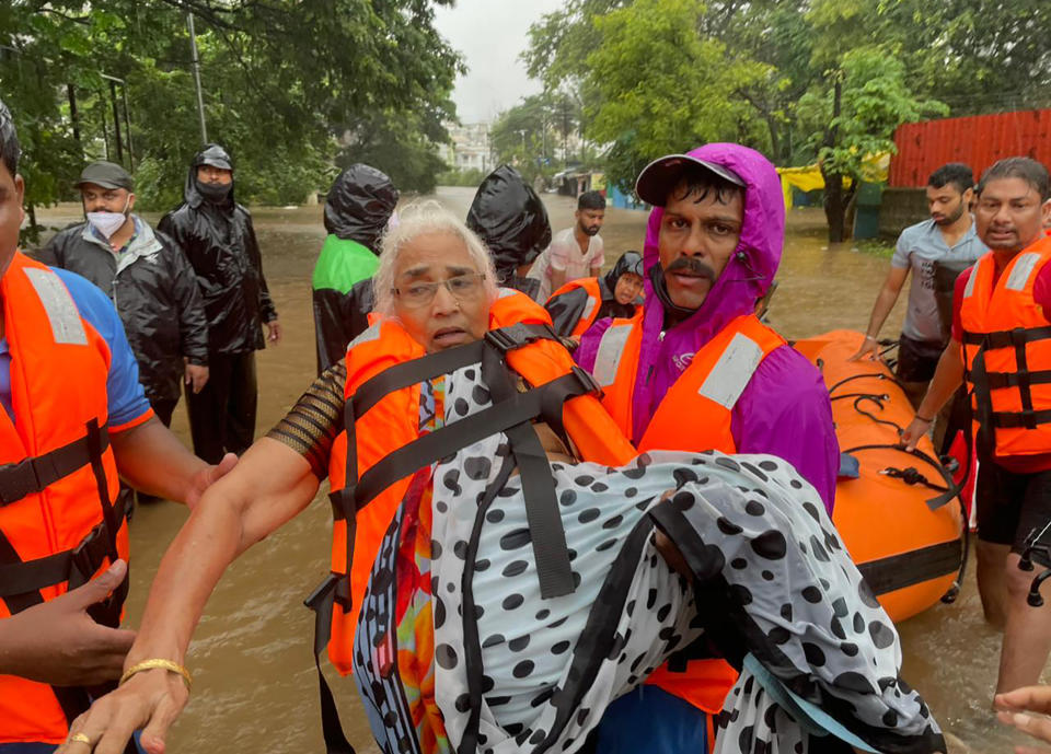 A National Disaster Response Force personnel rescues an elderly woman stranded in floodwaters in Kolhapur, in the western Indian state of Maharashtra, Friday, July 23, 2021. Landslides triggered by heavy monsoon rains hit parts of western India, killing at least 32 people and leading to the overnight rescue of more than 1,000 other people trapped by floodwaters, officials said Friday. (AP Photo)