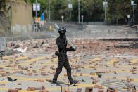 An anti-government protester walks on a road scattered with bricks outside the Polytechnic University in Hong Kong