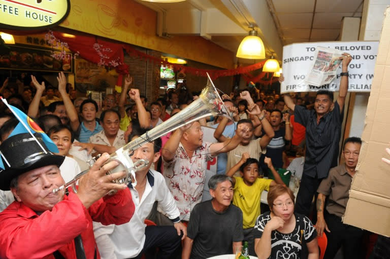 Workers' Party supporters celebrate after the results for the Punggol east by-election was announced