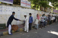 An Indian Muslim man distribute Kheer, a sweet dish to homeless people on Eid al-Fitr in Ahmedabad, India, Monday, May 25, 2020. The holiday of Eid al-Fitr, the end of the fasting month of Ramadan, a usually joyous three-day celebration has been significantly toned down as coronavirus cases soar. (AP Photo/Ajit Solanki)