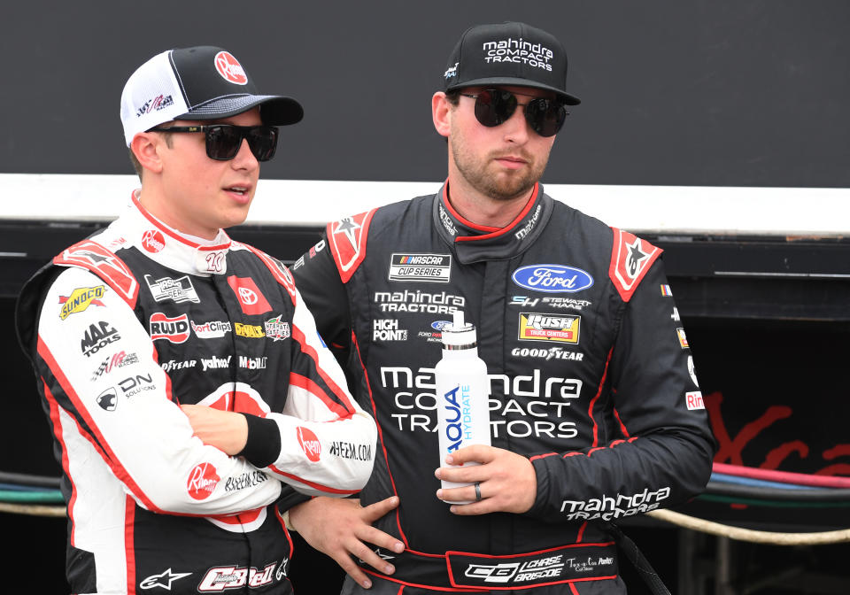 CHARLOTTE, NC - MAY 26: Christopher Bell (#20 Joe Gibbs Racing Rheem Toyota) and Chase Briscoe (#14 Stewart Haas Racing Mahindra Compact Tractors Ford) look on prior to the running of the NASCAR Cup Series Coca-Cola 600 on May 26, 2024, at Charlotte Motor Speedway in Concord, NC. (Photo by Jeffrey Vest/Icon Sportswire via Getty Images)