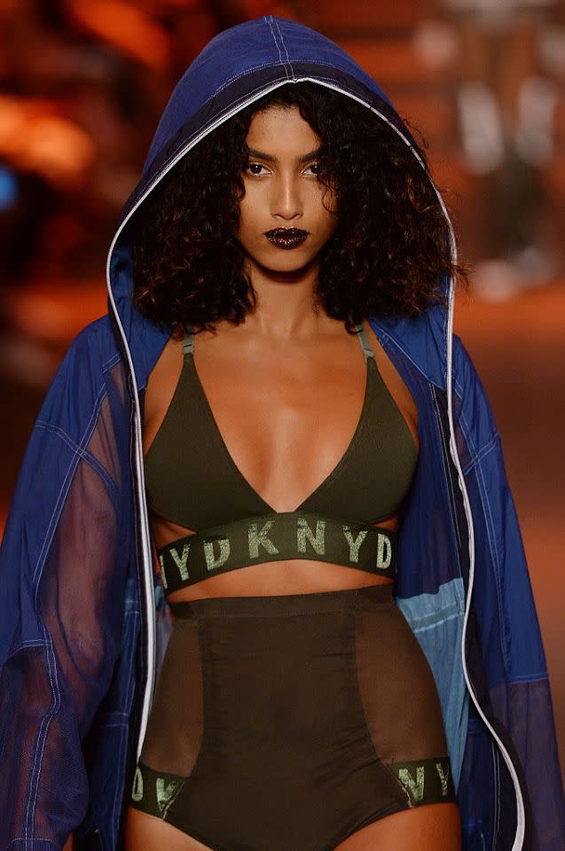 <p>Imaan Hamaam took the DKNY runway by storm in a deep red lip with a touch of metallic gold. (Photo: Getty) </p>