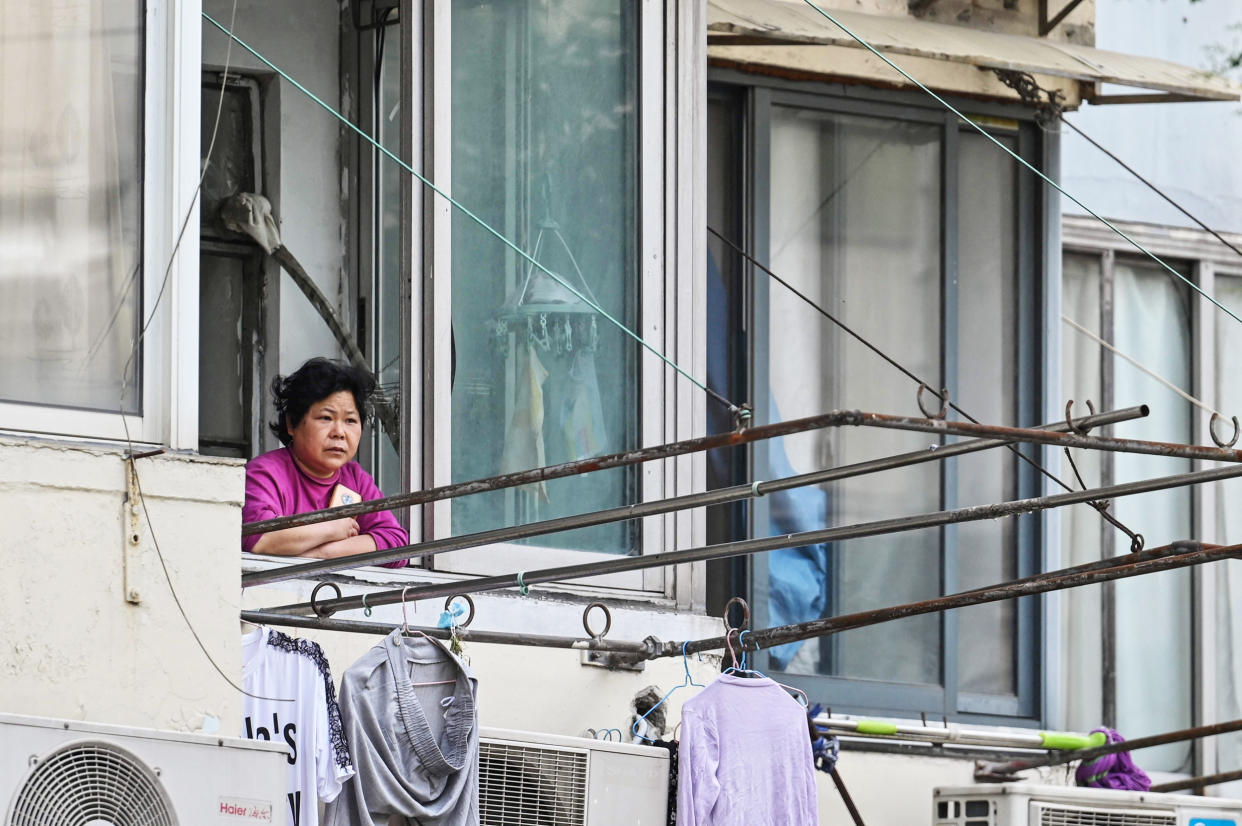 A resident looks out from her window (Hector Retamal / AFP via Getty Images)