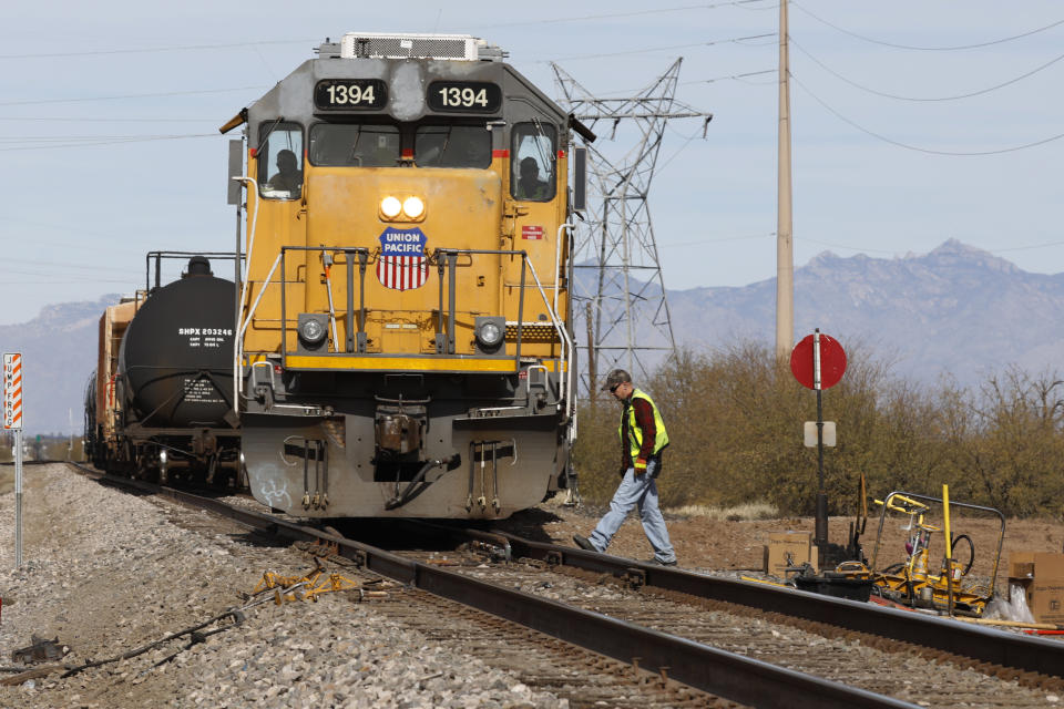 FILE - The crew on a Union Pacific freight train works at a siding area on Jan. 24, 2020, south of Tucson, Ariz. Rail unions want railroads to take some of the billions they’re using every year to buy back their stock and use it to improve safety in the wake of several high-profile derailments and hire more workers. (AP Photo/David Boe, File)