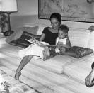 <p>Marlon Brando's ex-wife snuggles up with their son, Christian Brando, while reading him a book in 1961. </p>