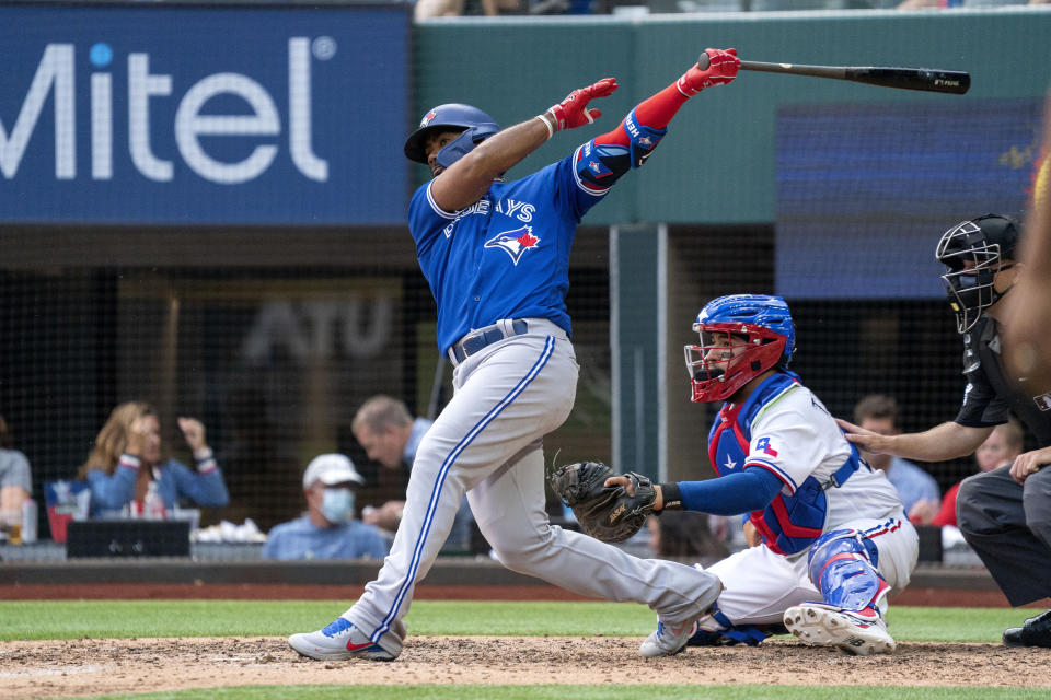 Toronto Blue Jays' Teoscar Hernandez follows through on a ground ball that scored Cavan Biggio on an error by Texas Rangers shortstop Charlie Culberson during the seventh inning of a baseball game Monday, April 5, 2021, in Arlington, Texas. (AP Photo/Jeffrey McWhorter)