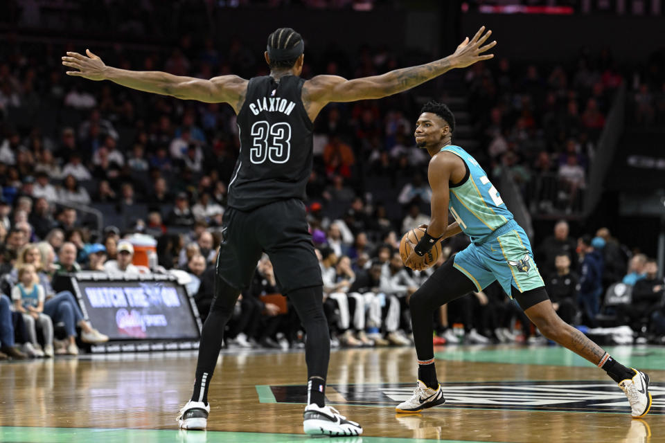 Charlotte Hornets forward Brandon Miller (24) looks to pass the ball away from Brooklyn Nets center Nic Claxton (33) during the first half of an NBA basketball game, Saturday, March 9, 2024, in Charlotte, N.C. (AP Photo/Matt Kelley)