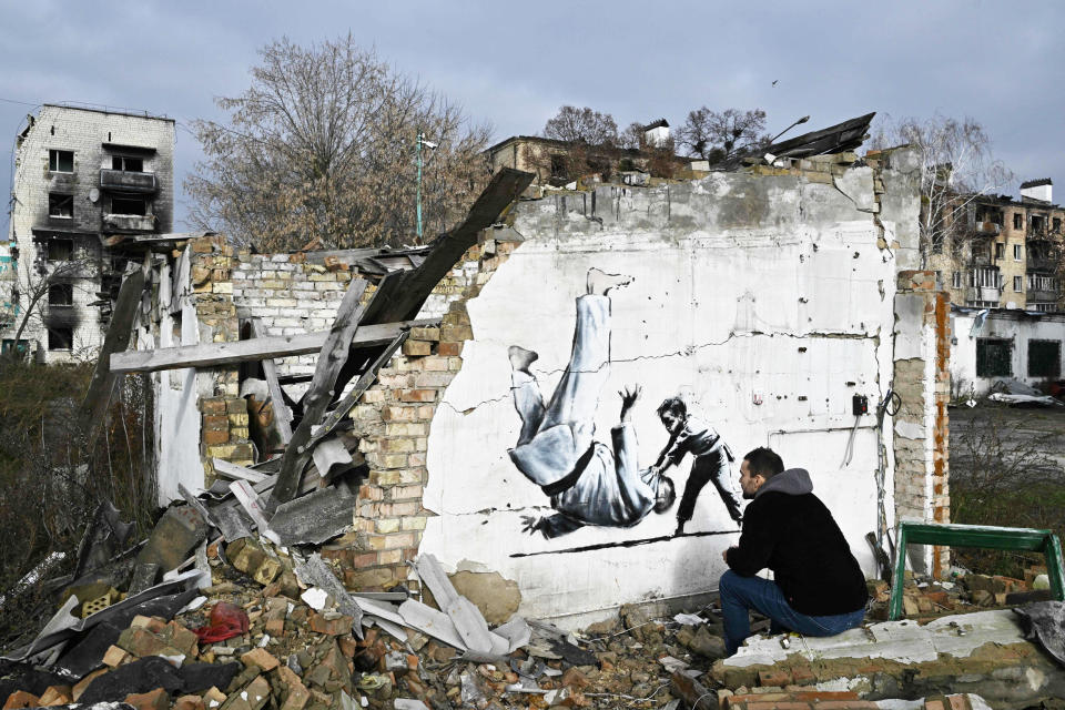 A person looks at Banksy-style graffiti on the wall of a destroyed building in Borodyanka, Ukraine  (Genya Savilov / AFP via Getty Images)