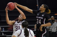 South Carolina guard LeLe Grissett (24) attempts to knock the ball away from Texas A&M forward N'dea Jones (31) during the first half of an NCAA college basketball game Sunday, Feb. 28, 2020, in College Station, Texas. (AP Photo/Sam Craft)