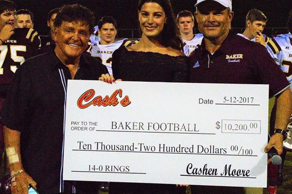 Cash and Cashen Moore present a check of $10,200 to the Baker High School football team