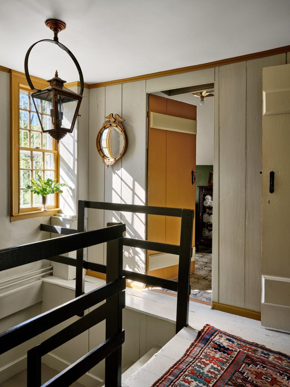 small stairwell from 1690 house painted in a creamy white color with ochre yellow trim