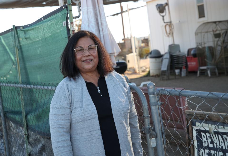 Nellie Perez stands outside her home in Niland, Calif., March 2, 2023. Her yard is devoid of grass or plants due to high water rates charged by the private Golden Coast Water Company, based in San Dimas, Calif.