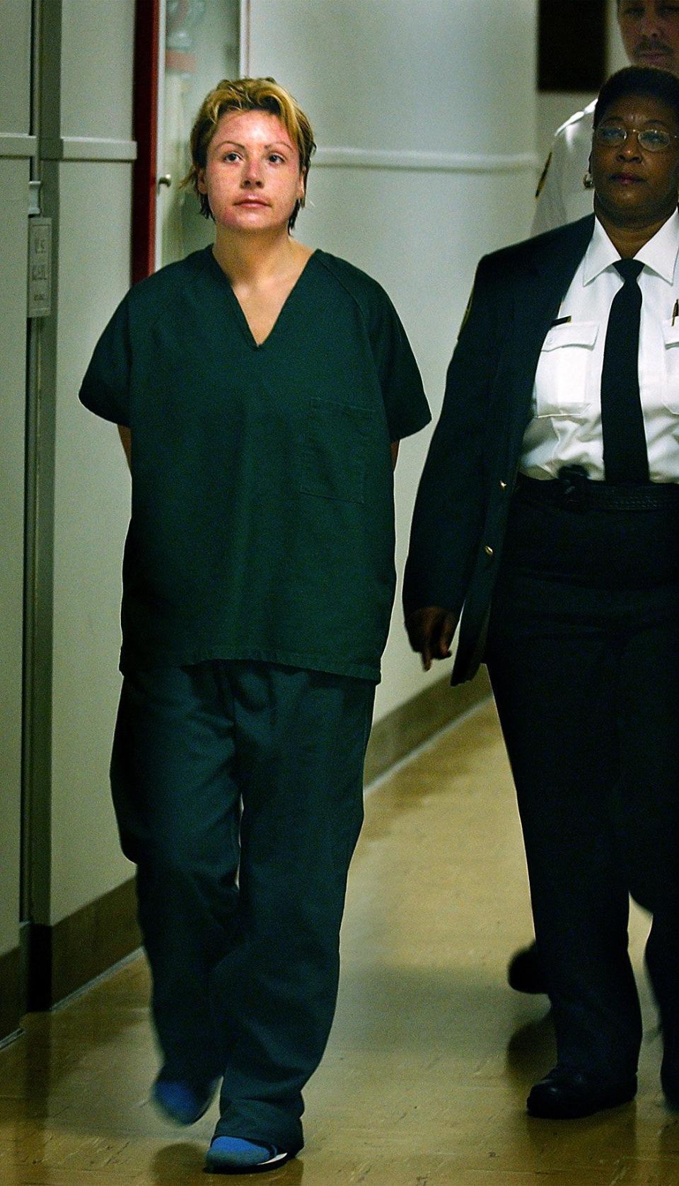 Michelle Theer is escorted to court in Broward County, Florida, on Aug. 12, 2002.  Theer waived extradition to North Carolina to face a murder charge in the death of her husband.