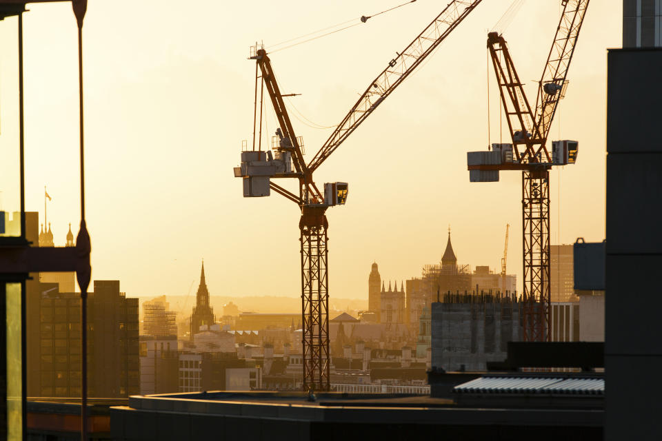 London skyline at sunset and silhouettes of construction cranes