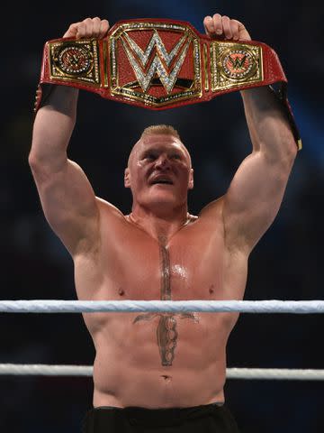 <p>FAYEZ NURELDINE/AFP/Getty</p> Brock Lesnar celebrates after winning the WWE Universal Championship on November 2, 2018.